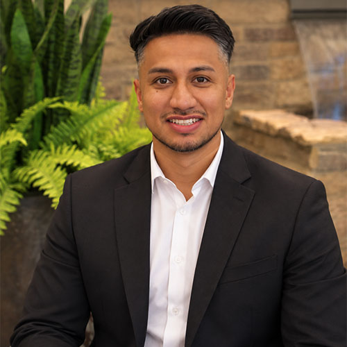Smiling man wearing a suit jacket and a button down shirt.